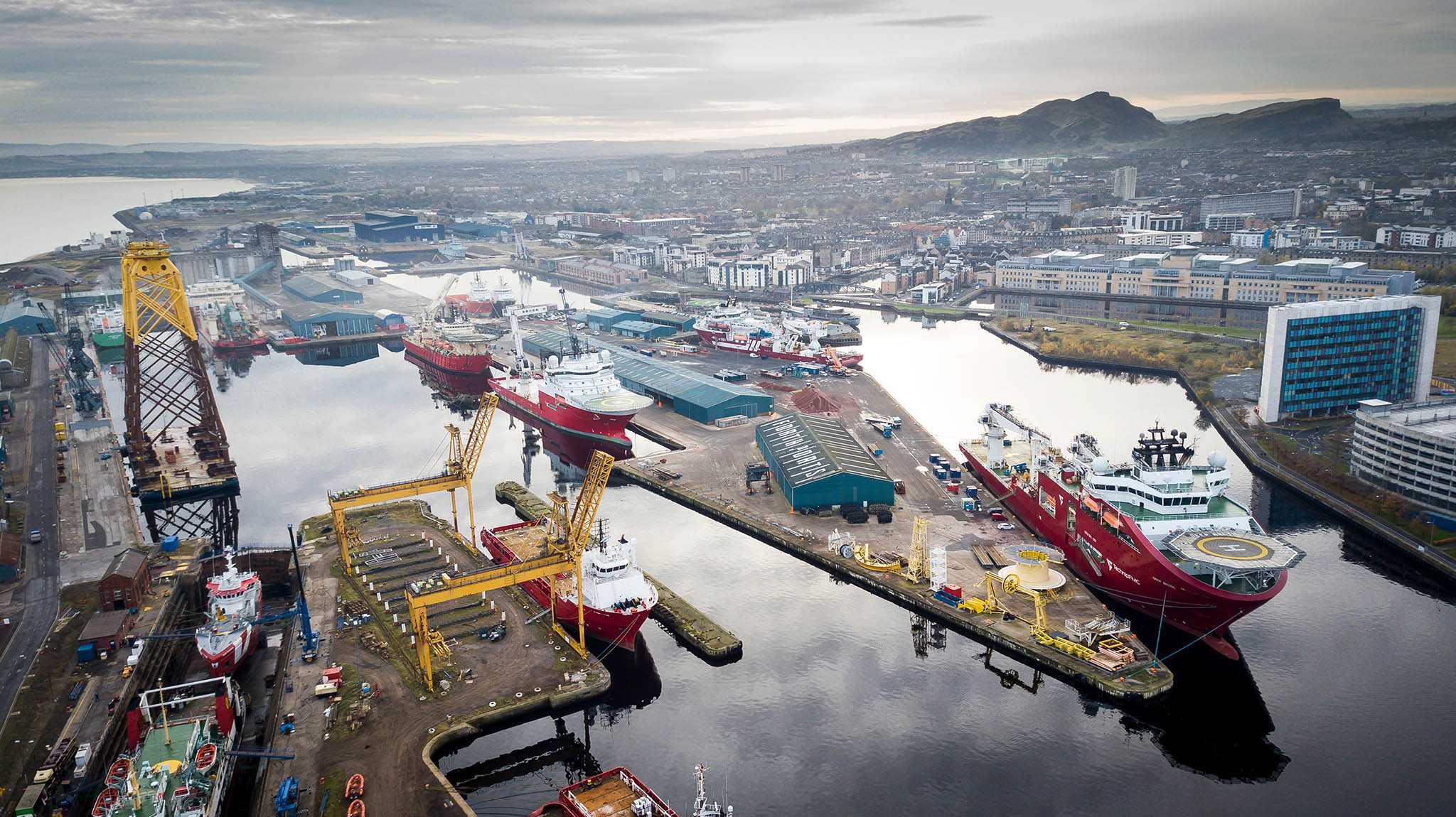 an aerial view of Forth Ports Leith full of oil and gas ships, with Arthur's Seat in the distance