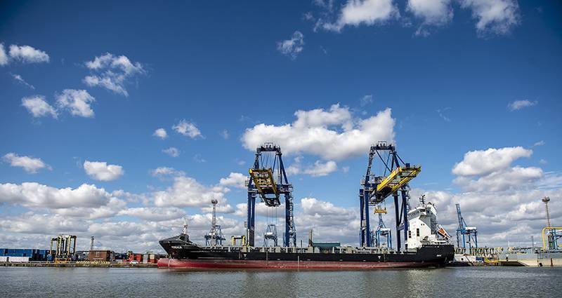 2 gantry cranes discharging container vessel at London container Terminal on sunny day